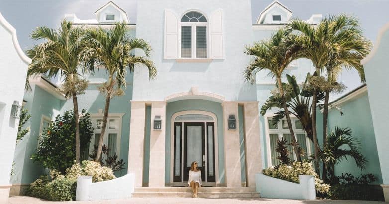 A tourist takes a picture in front of the elegant luxury house