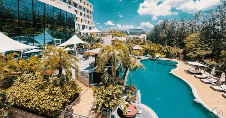 Aerial view of luxury hotel with large outdoor pool and eco-friendly environment